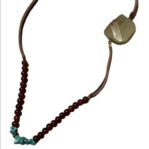 Garnet and turquoise beads on a leather cord.